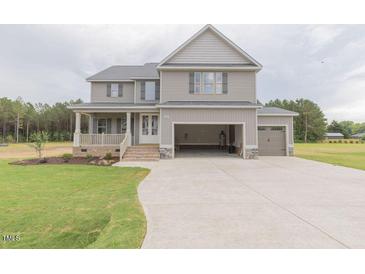 Charming two-story home featuring a covered porch, attached garage, and a well-manicured lawn at 66 Sanders Farm Dr, Smithfield, NC 27577