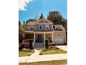 Charming two-story home featuring a welcoming front porch, well-manicured lawn, and attached two car garage at 102 Kipling Dr, Oxford, NC 27565