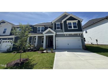 Charming home featuring gray siding, a two-car garage, and a well-manicured front lawn at 1033 Bostonian Dr, Knightdale, NC 27545