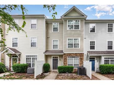 Charming multi-story townhouse with stone accents and well-maintained landscaping at 1220 Canyon Rock Ct # 107, Raleigh, NC 27610