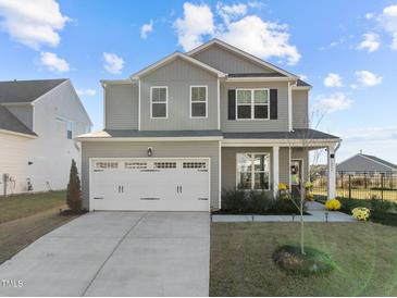Charming two-story home with a two-car garage and well-manicured lawn under a blue sky at 1236 Shadow Shade, Wake Forest, NC 27587