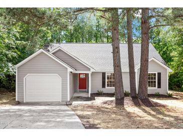 Charming one-story home with gray siding, a red front door, and an attached garage at 20 Meadowcrest Dr, Durham, NC 27703