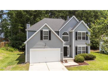 Charming two-story home with gray siding, black shutters, and a well-manicured lawn at 204 Trevor Ridge Dr, Holly Springs, NC 27540