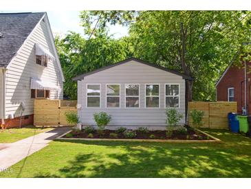 Charming exterior featuring a manicured lawn and neutral-colored siding with lovely curb appeal at 205 S Pettigrew St, Raleigh, NC 27610
