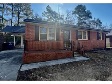 Charming brick home with a cozy front porch and covered carport at 2131 Dandridge Dr, Raleigh, NC 27610