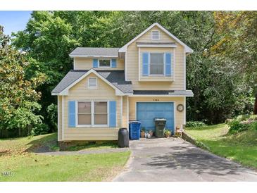 Charming two-story home with light yellow siding, blue shutters, and a single-car garage at 2308 Stonesthrow Ct, Raleigh, NC 27610