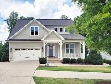 Charming home featuring a covered porch, well-maintained landscaping, and a two-car garage at 2409 Plowridge Rd, Fuquay Varina, NC 27526