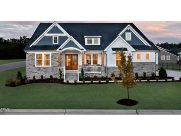 Charming two-story home featuring a stone facade, manicured lawn, and inviting front porch at 249 Lindo Johnson Rd, Pittsboro, NC 27312