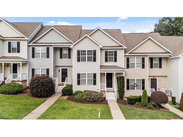 Well-maintained townhouse with neutral siding, black shutters, and a landscaped front yard at 407 Whitehall Ct, Clayton, NC 27520