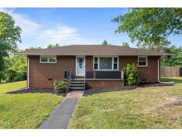 Charming brick home featuring a well-manicured lawn and inviting front entry at 464 Camp Rd, Burlington, NC 27217