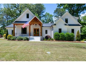 Beautiful two-story white home featuring a welcoming front porch, wood accents and an American flag at 512 Page St, Cary, NC 27511