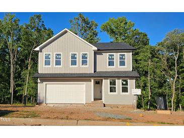 Charming two-story home features a grey exterior, black roof, a 2-car garage, and manicured landscaping at 633 Conover Rd, Durham, NC 27703