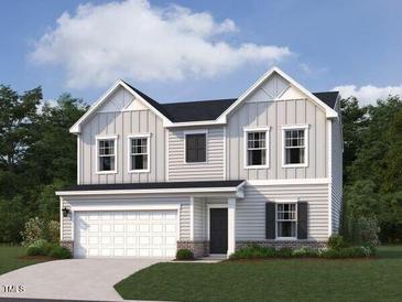 Charming two-story home with a two-car garage, manicured lawn, and classic architectural details at 11121 Salers Loop, Middlesex, NC 27557