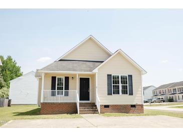 Charming single-story home with a cozy front porch and well-maintained lawn on a sunny day at 12 Linsey Ct, Lillington, NC 27546
