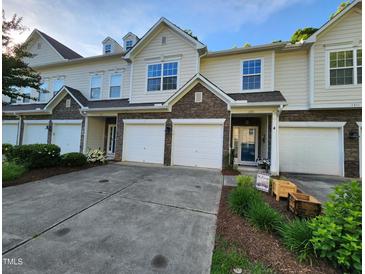 Inviting townhouse exterior with stone accents, attached garages, and landscaped front yard at 1309 Bartlett Cir, Hillsborough, NC 27278