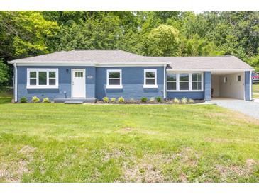 Charming blue brick home with a well-manicured lawn and an inviting covered parking area at 1917 Tucker St, Burlington, NC 27215