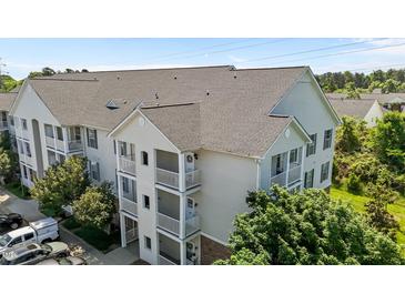 A three-story building showing multiple balconies with white railings and light colored facade at 3015 Winston Dr # 117, Burlington, NC 27215