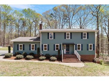 Charming two-story home with a brick staircase and manicured landscaping at 3418 Carriage Trl, Hillsborough, NC 27278