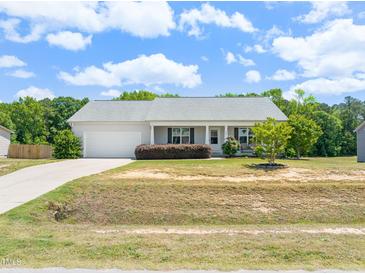 Charming single-story home with a well-manicured lawn and an attached two-car garage at 357 Sherrill Farm Dr, Benson, NC 27504