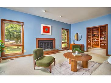 Bright living room featuring hardwood floors, a fireplace, and large windows with natural light at 37 Wedgewood Rd, Chapel Hill, NC 27514