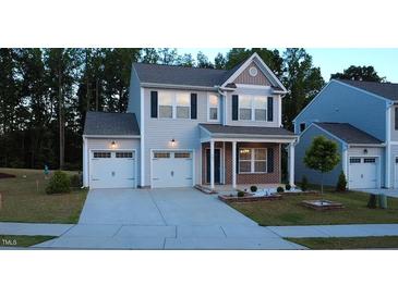 Charming two-story home boasts a two-car garage, covered porch, and well-maintained landscaping at 391 Curling Creek Dr Dr, Clayton, NC 27527