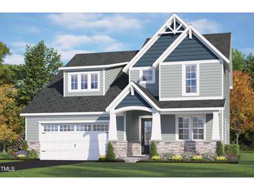 Inviting home showcasing stone accents, a two-car garage, and manicured lawn under a bright blue sky at 40 W Victoria Ridge Dr # 18, Selma, NC 27576