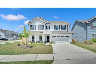 Charming two-story home with a well-manicured lawn, a two-car garage, and dark shutters at 4601 Okeechobee Ct, Fuquay Varina, NC 27526