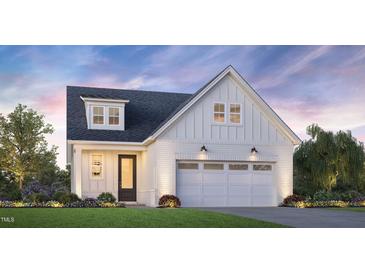Charming new construction featuring white brick and siding, a two-car garage, and a welcoming front yard at 5217 Bowes Meadow Ct # 14, Raleigh, NC 27610