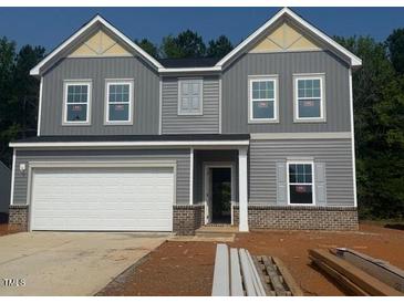 Charming two-story home with gray siding, a two-car garage, and a well-manicured lawn at 6828 Galloway Dr, Middlesex, NC 27557