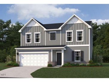 Charming two-story home with gray siding, white trim, and a two-car garage on a well manicured lawn at 6828 Galloway Dr, Middlesex, NC 27557