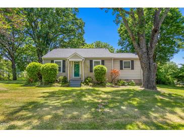 Charming single-story home featuring a well-manicured lawn and mature trees at 701 Veterans Dr, Elon, NC 27244