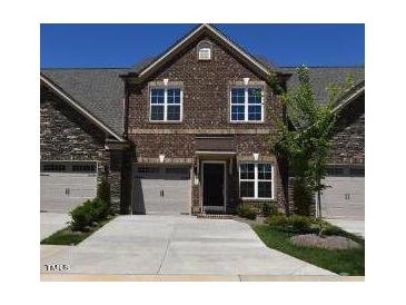 Charming townhome featuring a brick facade, attached garage, and manicured front lawn at 1033 Talisker Way # 16, Burlington, NC 27215