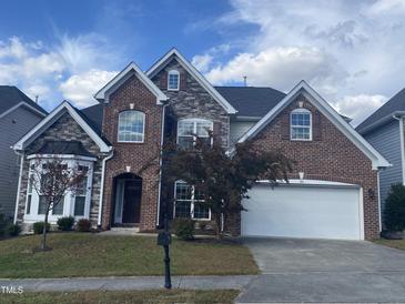 Two-story brick and stone home with attached two-car garage and manicured front yard at 104 Elmsford St, Durham, NC 27703