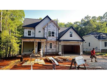 New construction featuring a two-story home with an attached two-car garage in a wooded setting at 188 Buckaroo Dr, Louisburg, NC 27549