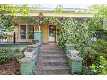 Charming home featuring a welcoming front porch with flowering vines and a decorative sun ornament at 206 N State St, Raleigh, NC 27601