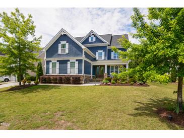 Beautiful two-story blue home with a well-manicured lawn and mature trees at 2601 Brookstone Ridge, Raleigh, NC 27613