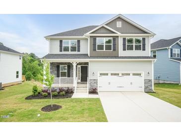 Charming two-story home with light gray siding, stone accents, and a two-car garage at 283 Hopewell Br Ct, Smithfield, NC 27577