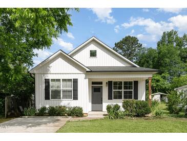 Charming home featuring a gray door, black shutters, and lush lawn with a traditional design at 303 Godwin St, Selma, NC 27576
