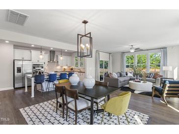 Bright open-concept living area featuring modern decor, stainless steel appliances, and lots of natural light at 327 Augusta Pond Way # 172, Raleigh, NC 27603