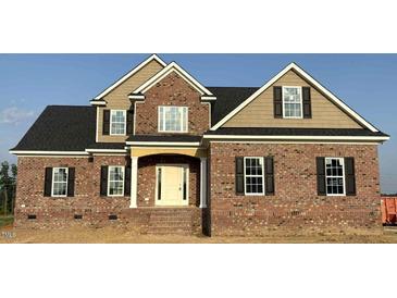 New construction home boasts a brick exterior, complemented by tan siding and black shutters at 7491 Sweetwater Dr, Nashville, NC 27856