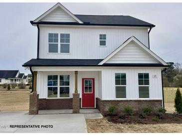 Charming two-story home featuring white siding, black roof, brick accents and a bright red front door at 117 Legolas Ct, Middlesex, NC 27557