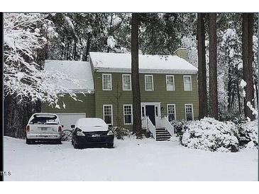 Traditional two-story home featuring a classic facade and a snow-covered front yard with mature trees at 14 Striding Ridge Ct, Durham, NC 27713