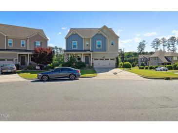 Charming two-story home with a two-car garage, blue accents, and a well-maintained front yard at 1600 Tinos Overlook Way, Apex, NC 27502
