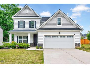 Charming two-story home featuring a well-manicured lawn, covered porch, and a two-car garage at 200 Chateau Way, Angier, NC 27501