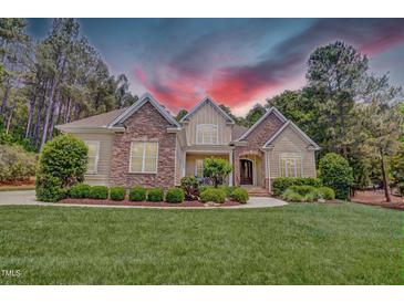 Beautiful home featuring stone accents, manicured lawn, and professional landscaping at 216 Colonial Ridge Dr, Pittsboro, NC 27312