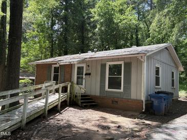 Quaint single-story home with a mix of brick and siding, complemented by lush greenery at 317 Gary St, Durham, NC 27703