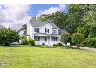 Inviting two-story home with a well-manicured lawn and charming front porch, perfect for relaxing outdoors at 59 Troy Dr, Fuquay Varina, NC 27526