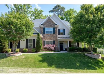 Charming two-story home with stone accents, a landscaped yard, and mature trees at 713 Liberty Cliff Dr, Cary, NC 27519