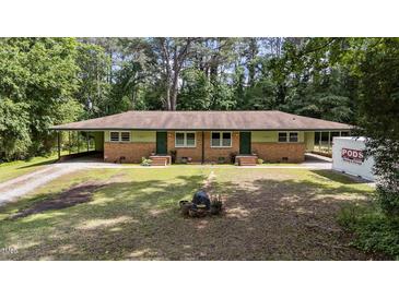 Charming duplex with brick exterior, green trim, and spacious yard in a wooded setting at 725-727 Locust Ln, Raleigh, NC 27603
