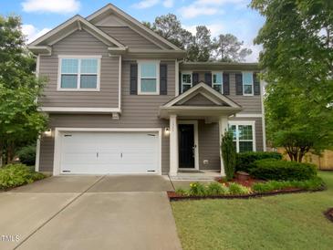 Charming two-story home with gray siding, black shutters, an attached two-car garage, and manicured landscaping at 8844 Forester Ln, Apex, NC 27539